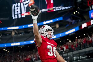 UNLV linebacker Charles Correa holds a football in the air gesturing at the crowd after scoring a touchdown off of a blocked punt in the third quarter against Syracuse. 