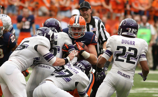 Syracuse fullback Carl Cutler is stopped by Northwestern defenders.