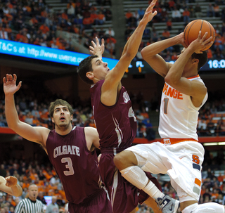 Michael Carter-Williams goes up for a shot as Colgate's Luke Roh (4) and John Brandenburg (3) challenge him.