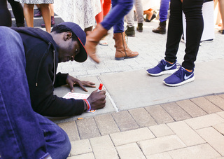 Demarquez Grissom, a sports coach and sophomore recreation selective studies major, creates his poster at the 